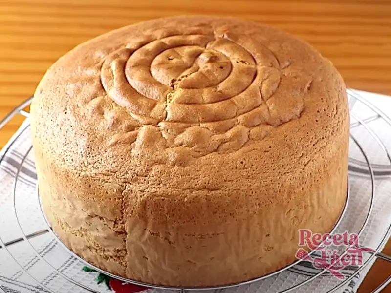 Vista de un bizcocho esponjoso recién horneado sobre una tabla de madera
