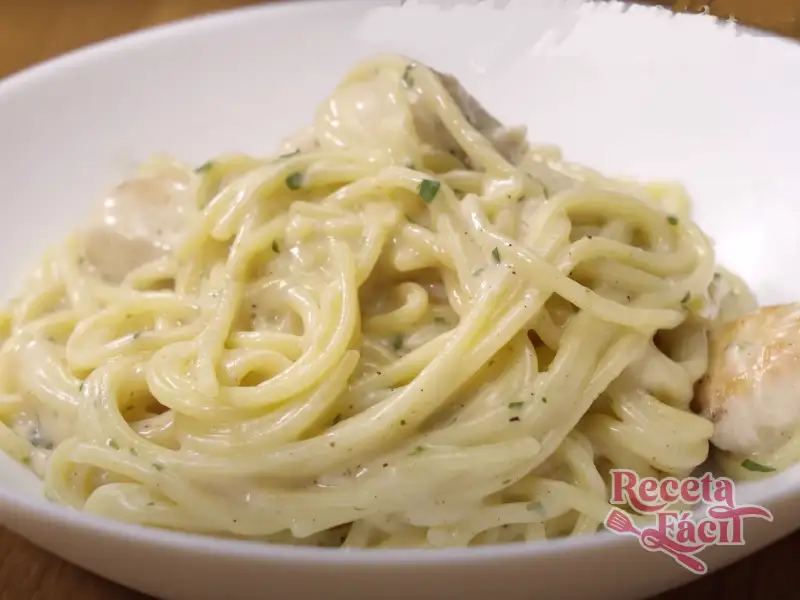 Plato de spaghetti con salsa alfredo y trozos de pollo encima