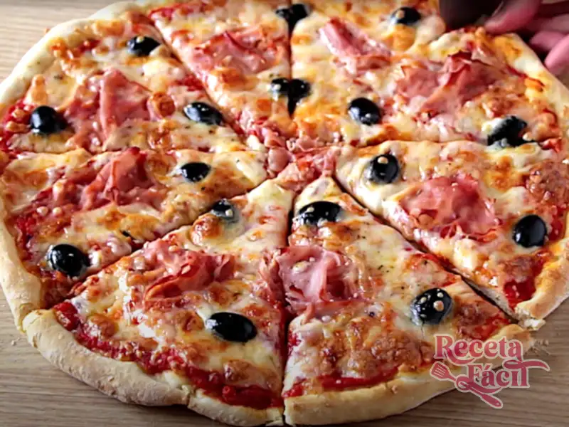 Pizza casera con tomate, mozarrella, jamón cocido y aceitunas