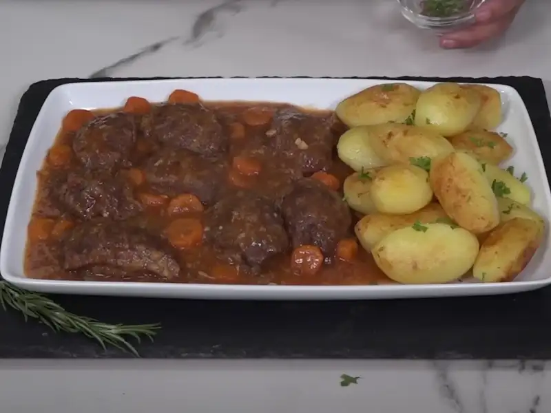 Plato de carrilleras de cerdo en salsa con patatas fritas