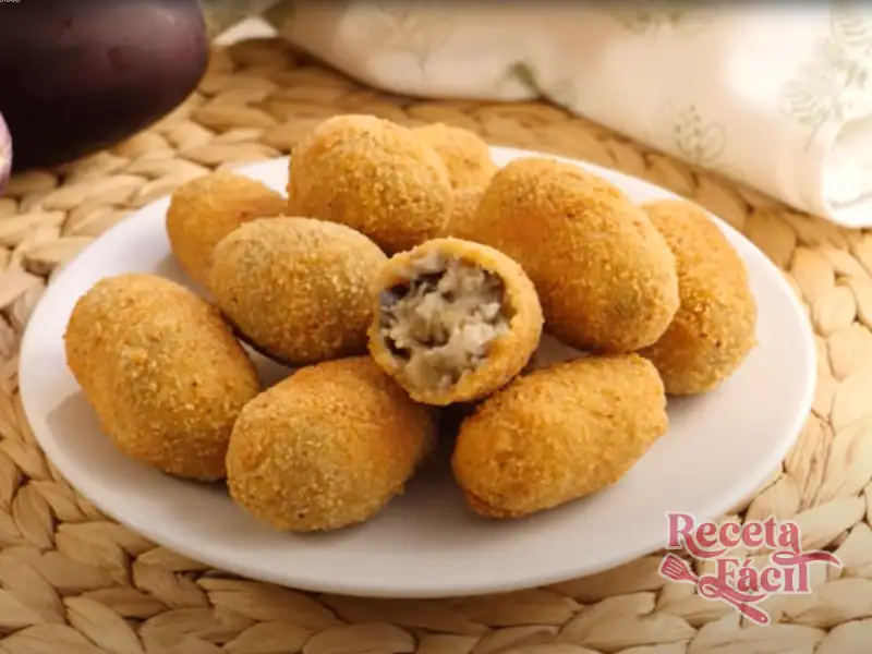 Croquetas de berenjena caseras doradas en plato blanco