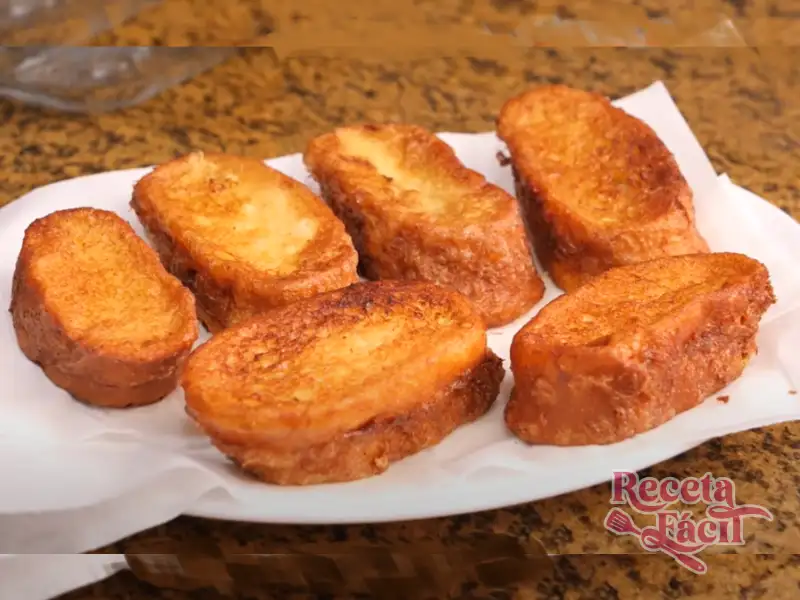 Torrijas de leche caseras espolvoreadas con canela en una mesa de madera