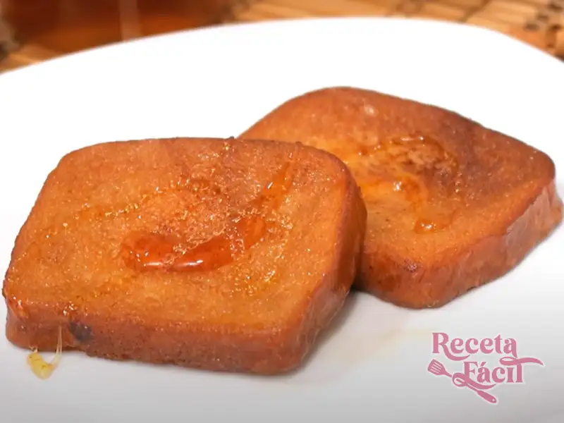 Torrijas de miel y vino doradas y jugosas sobre un plato blanco