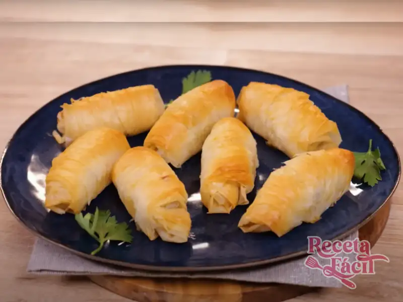 Rollitos de pollo y queso feta envueltos en pasta filo dorados y crujientes en un plato