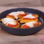 Escalopes de Pollo Empanadas con Tomate y Mozzarella servidos en plato elegante