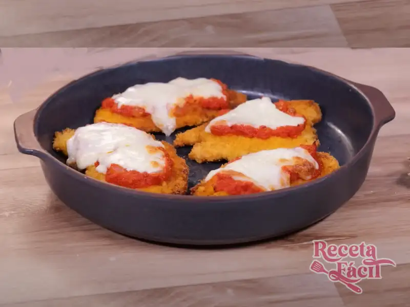 Escalopes de Pollo Empanadas con Tomate y Mozzarella servidos en plato elegante